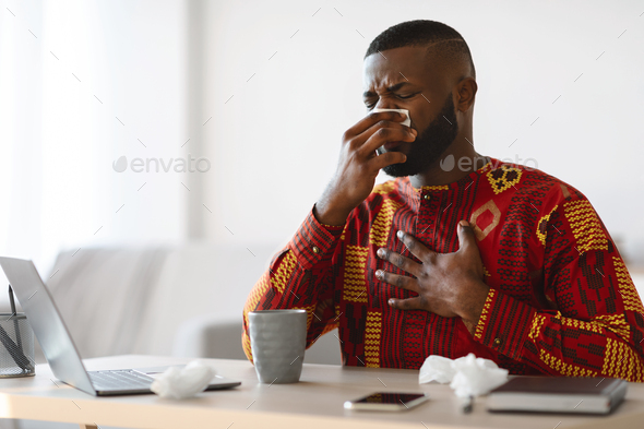 Coronavirus Symptoms. Black Freelancer Guy In Ethnic Costume Feeling Sick At Home