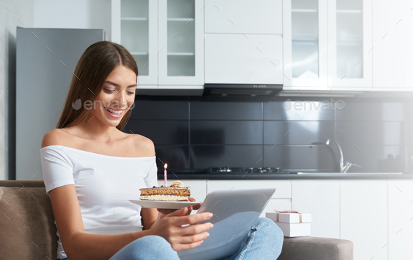 Woman with cake celebrating birthday online