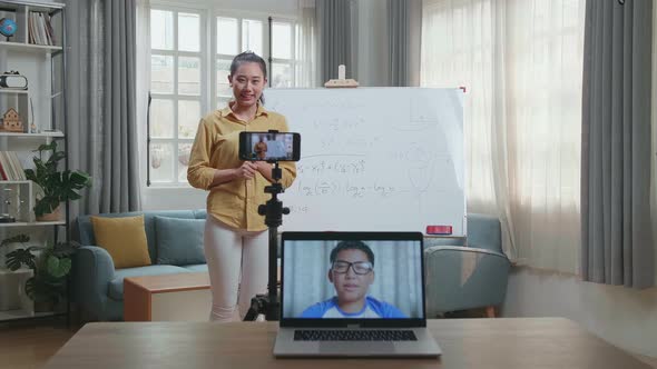 Female Teacher Having Video Call On Laptop While Teaching Math Online At Home alt