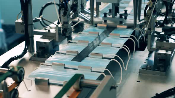 Elastics Are Getting Mechanically Attached To the Face Masks. Covid-19 Prevention Masks Production alt