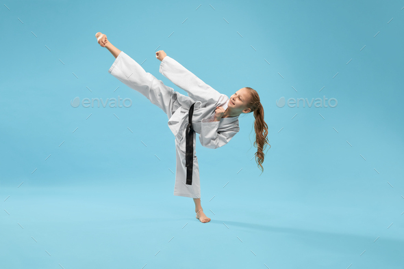Girl in kimono practicing kick foot forward