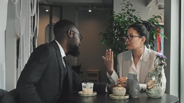 Business Partners Having Conversation in Cafe alt