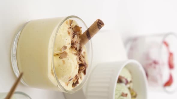 Vertical video: Set of different flavors of ice cream in glasses alt