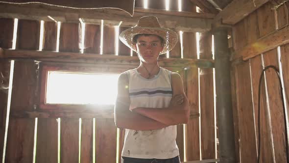 Adolescent Boy in Straw Hat in the Farmers Country Barn Viewed From Low Angle Standing with and alt