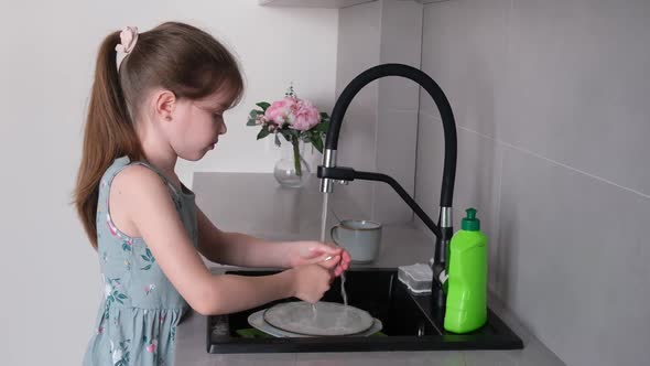 Little Girl Helping Mom Wash the Dishes