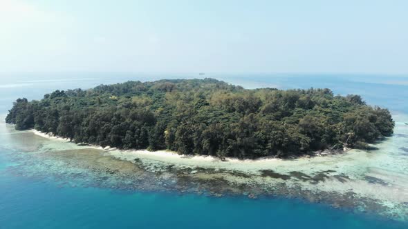 Cinematic aerial view of island in the beautiful blue ocean.