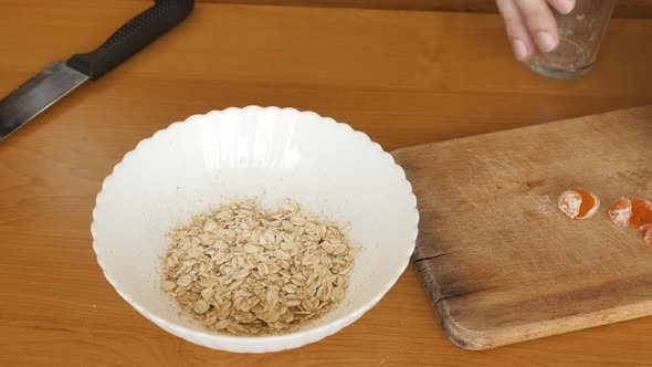 Cooking Pouring Hot Water to Oat Flakes