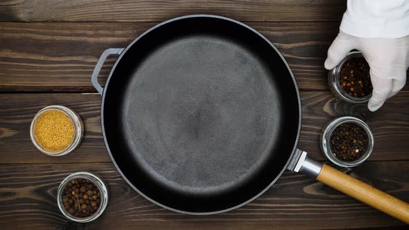 Cast iron pan for frying meat. A professional chef prepares to cooking meat in a skillet. peppercorn