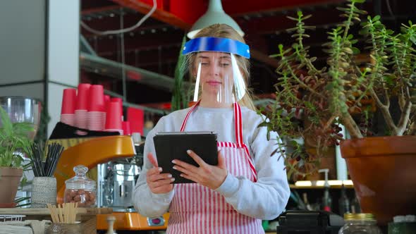 Female Barista in Face Shield Using Tablet PC alt