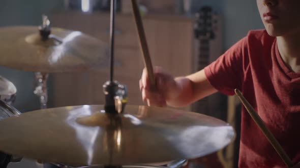 Teenager Learning to Play Drum Kit alt