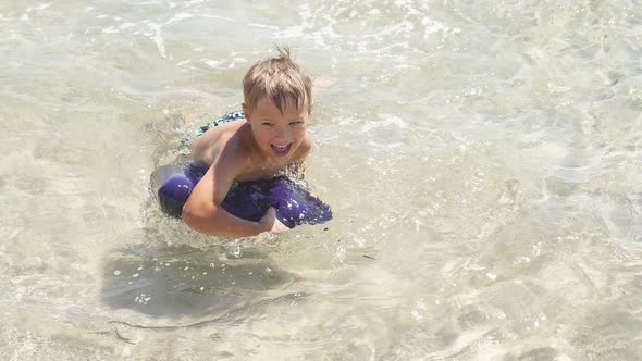 Closeup of a Boy Swimming in the Purest Azure Sea in Shallow Water