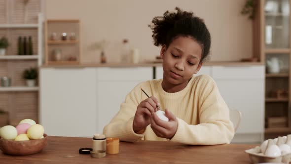 Girl Painting on Egg for Easter alt