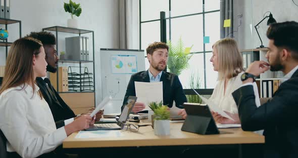 Bearded Boss Talking to His Multiracial Male and Female Corporate coworkers alt