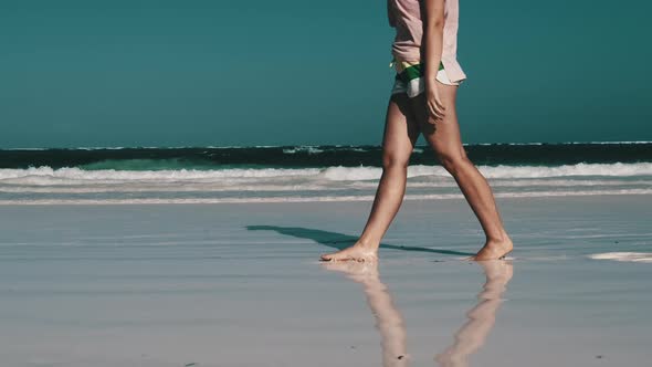 Legs of Young Woman Walking By White Sand Paradise Beach with Tidal Ocean Waves alt