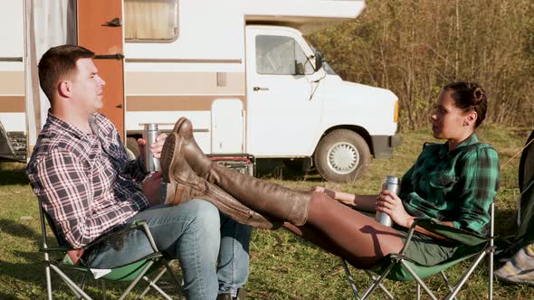 Caucasian Copuple Relaxing Together on Camping Chairs alt