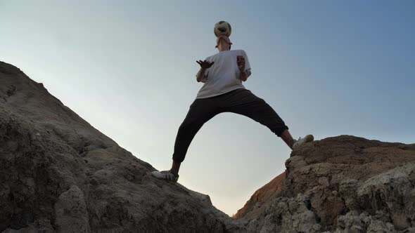 Freestyler Balancing a Ball on His Head Among the Rocks alt