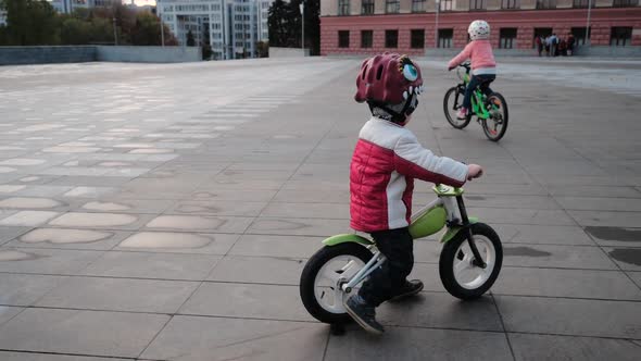 Little Smiling Happy Boy and Girl Are Riding Bicycles in a City Park, Close-up, Kharkov, Ukraine alt