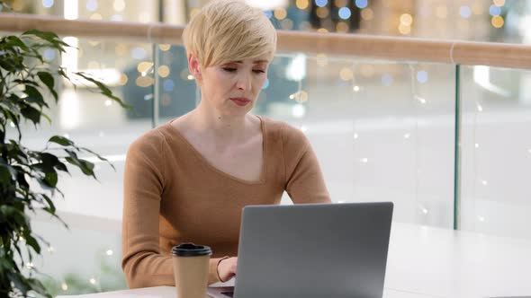 Caucasian Adult Mature Stressed Woman Working on Laptop Worry System Virus Looking at Laptop alt