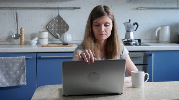 Female Freelancer Working with Laptop at Kitchen alt
