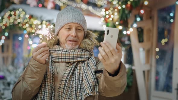 An Elderly Man with Sparklers Calls His Relatives Via Video Link on New Year's Eve to the Chiming of