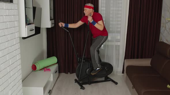 Active Healthy Senior Old Mature Man in Sportswear Using Orbitrek Training Cardio Workout at Home alt