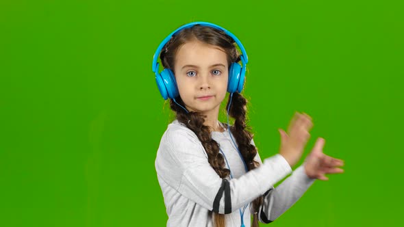 Baby in the Headphones Is Listening To Music. Green Screen alt