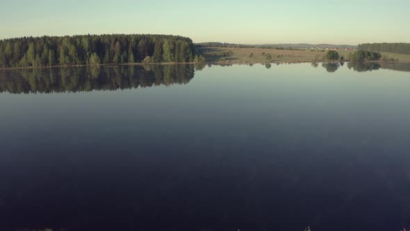 Man Fishing on Wooden Pier Near Lake