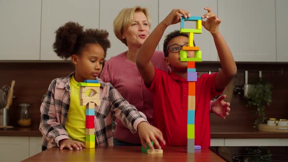 Excited Cute Multiethnic Children and Grandma Having Fun Playing at Home alt