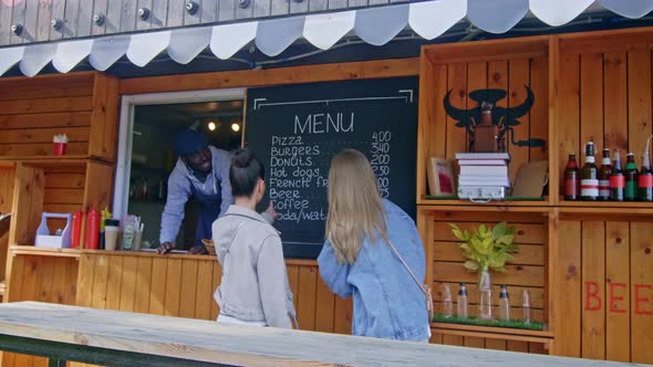 Two girls choosing their food by street cafe