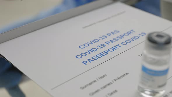 Crop View of Medical Worker Hand Putting Stamp on Carton COVID19 Vaccine Immunization Card alt