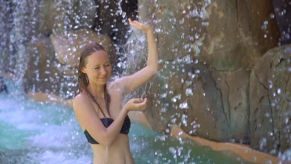 A Young Woman in a Tropical Resort with Hot Springs, Waterfalls and Swimming Pools with Hot Mineral alt