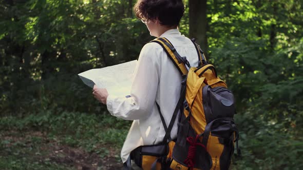 A Girl A Tourist Walks With A Map In Her Hands Moves Through The Forest, A Young Girl Walks With alt