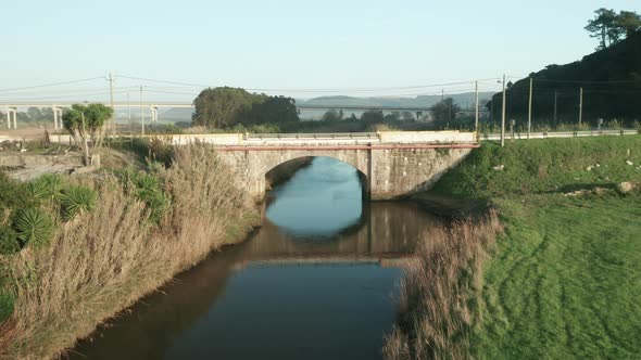 Flying Towards Old Stone Arch Bridge Over Tranquil Lake Of Alcobaca River Near Nazare, Portugal. - D alt