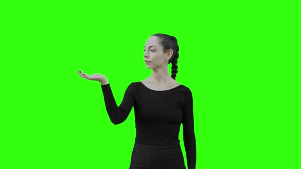 Young Woman Communicate With a Virtual Entity by Blowing Air with Green Screen. alt