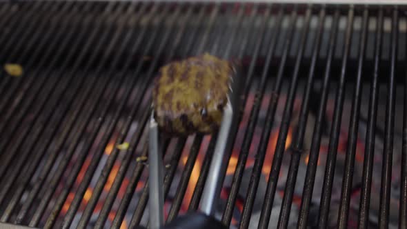 Chef Preparing Tasty Meat on the Grill, Turning It with Tongs alt