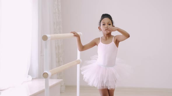 Little African Girl Practicing Choreographic Elements on Ballet Barre alt