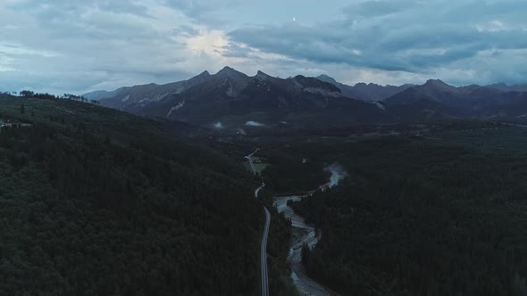 Aerial backward over Bialka river with mountains in background. Jurgow, Poland alt