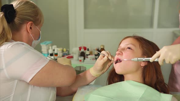 The Doctor Heals the Teeth of the Girl the Woman Removes Tooth Decay with Drill alt