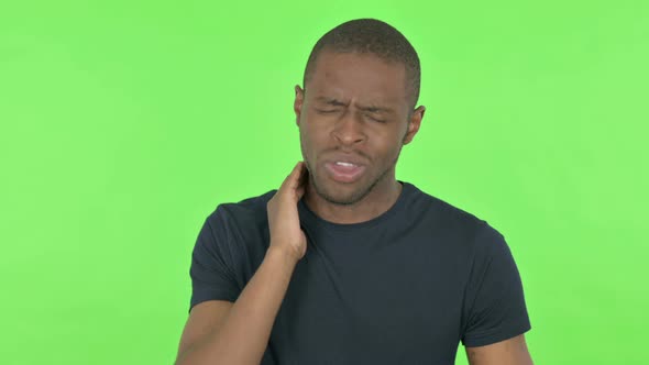 Young African Man with Neck Pain on Green Background alt