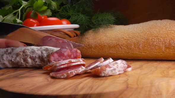 Knife Cuts Off a Piece of Smoked Spicy Sausage alt