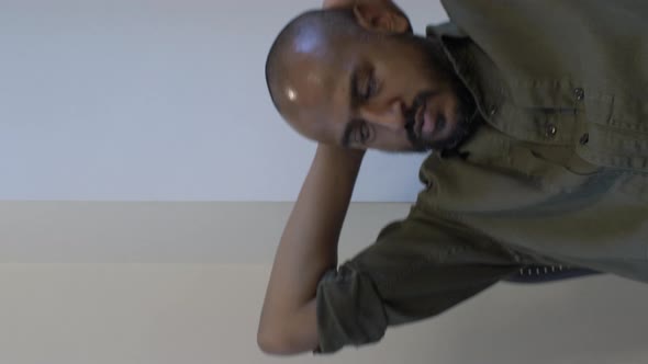 Ethnic Minority Male Swivelling On Chair With Hands Behind Head. Vertical Video, Locked Off alt