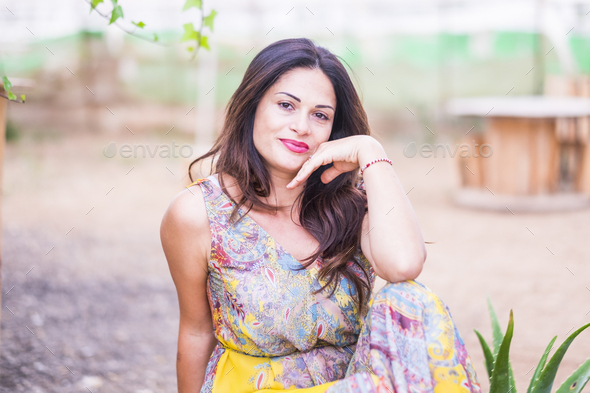 Beautiful young woman posing with coloured dress outdoor smiling at the camera - Stock Photo - Images