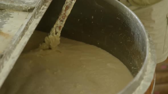 Male worker stirring gin in distillery 4k alt