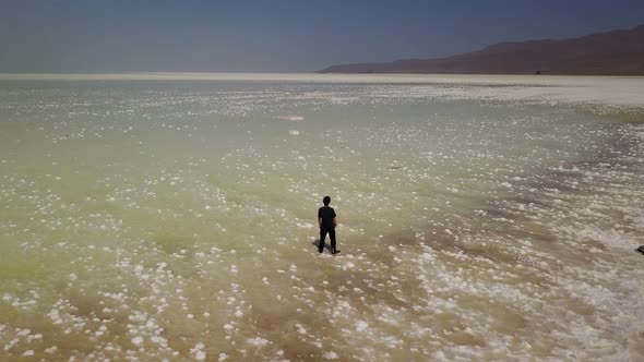 Single Man Lonely on White Urmia Salt Lake in Iran