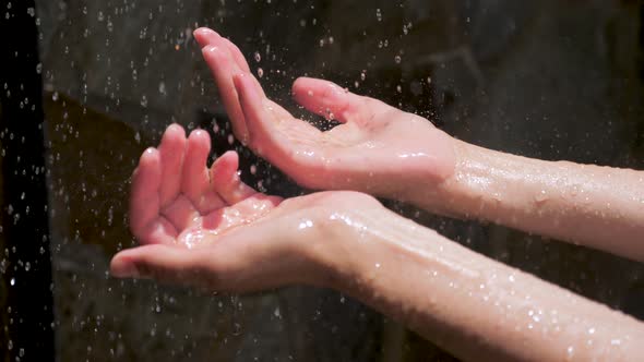 Female Hands Playing with Water Drops