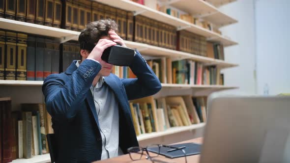Young man entering office and working wearing 3D viewer alt