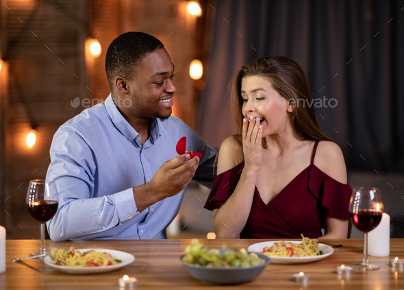 Marriage Proposal. Romantic Black Boyfriend Proposing Girlfriend To Marry Him In Restaurant