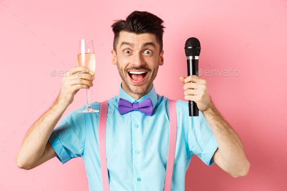 Party and festive events concept. Cheerful young male entertainer, giving speech on holiday, raising