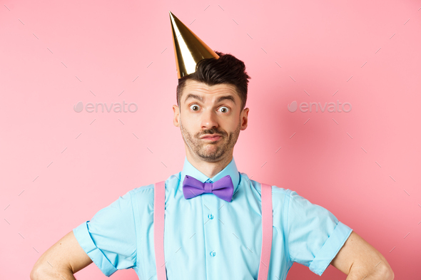Holidays and celebration concept. Close-up of confused male entertainer in party hat and bow-tie