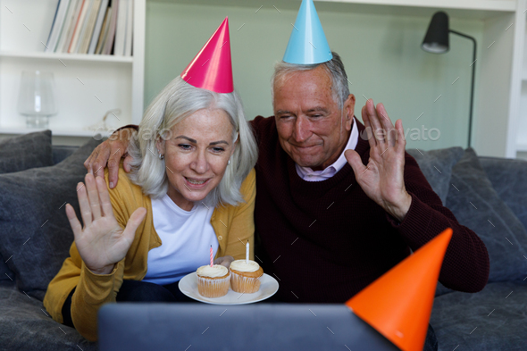 Senior caucasian couple celebrating birthday while having a video chat on laptop at home - Stock Photo - Images